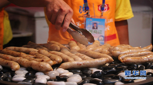 【組圖】兩岸特色廟會以“食”會友 兩岸各大夜市的招牌美食集聚特色廟會,圖為鵝卵石上的香腸,香氣四溢。新華網 劉默……