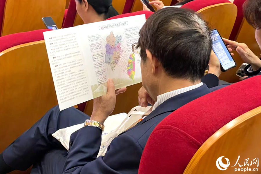 一位嘉賓認真端詳姓氏入閩及遷臺示意圖。人民網記者 林盈攝