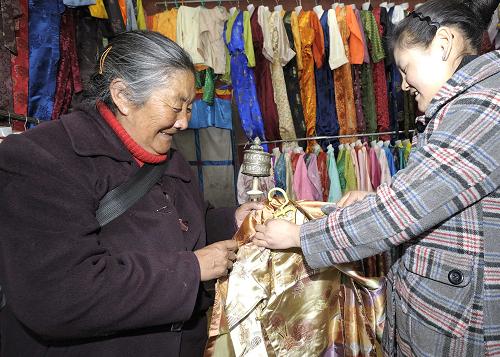 2月18日,一名藏族老阿媽在選購藏裝。藏歷新年來臨之際,藏裝作為藏族傳統節日必穿的服飾受到廣大藏族群眾的青睞。新華社記者 普布扎西 攝