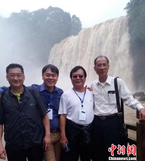 臺(tái)商們?cè)邳S果樹瀑布前合影。 劉鵬 攝