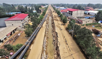 洪水將坑內的管道沖到路邊。京華時報記者潘之望攝