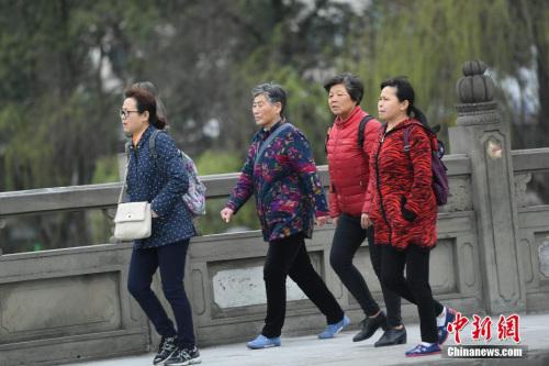 3月14日,四川成都街頭行人身著厚衣物出行。受北方冷空氣影響,四川盆地連日來氣溫持續走低,局部還出現了降雪天氣,民眾紛紛添加厚衣物御寒。 中新社記者 張浪 攝