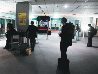 第二航廈長廊及候機樓一片漆黑,只靠緊急出口的照明燈提供少量光源。圖片來源:臺灣《聯合報》