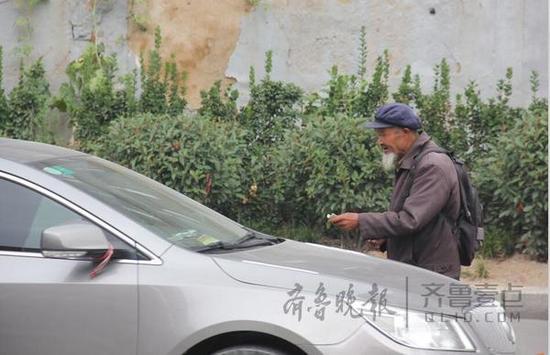泰安龍?zhí)堵泛挽`山大街交口附近,一名乞討者正在攔車(chē)乞討。