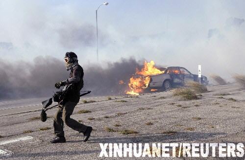 10月21日,一名新聞?dòng)浾咴诿绹永D醽喼蓠R利布地區(qū)山林大火現(xiàn)場走過燃燒的小汽車。當(dāng)天,距離洛杉磯西南約30公里的馬利布地區(qū)發(fā)生山林大火,目前已造成至少500英畝的山林和數(shù)幢建筑物被毀,數(shù)百人被緊急疏散。 新華社/路透