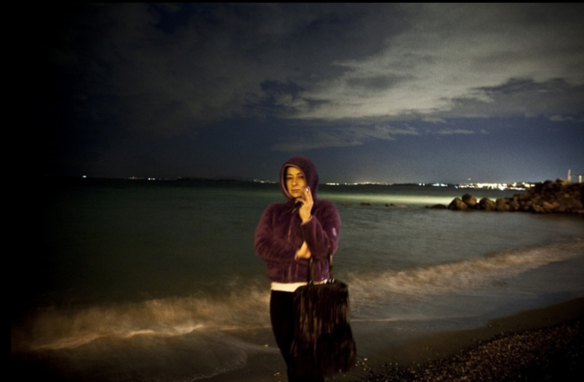 Tenya在沙灘上抽煙,她在附近的酒店工作